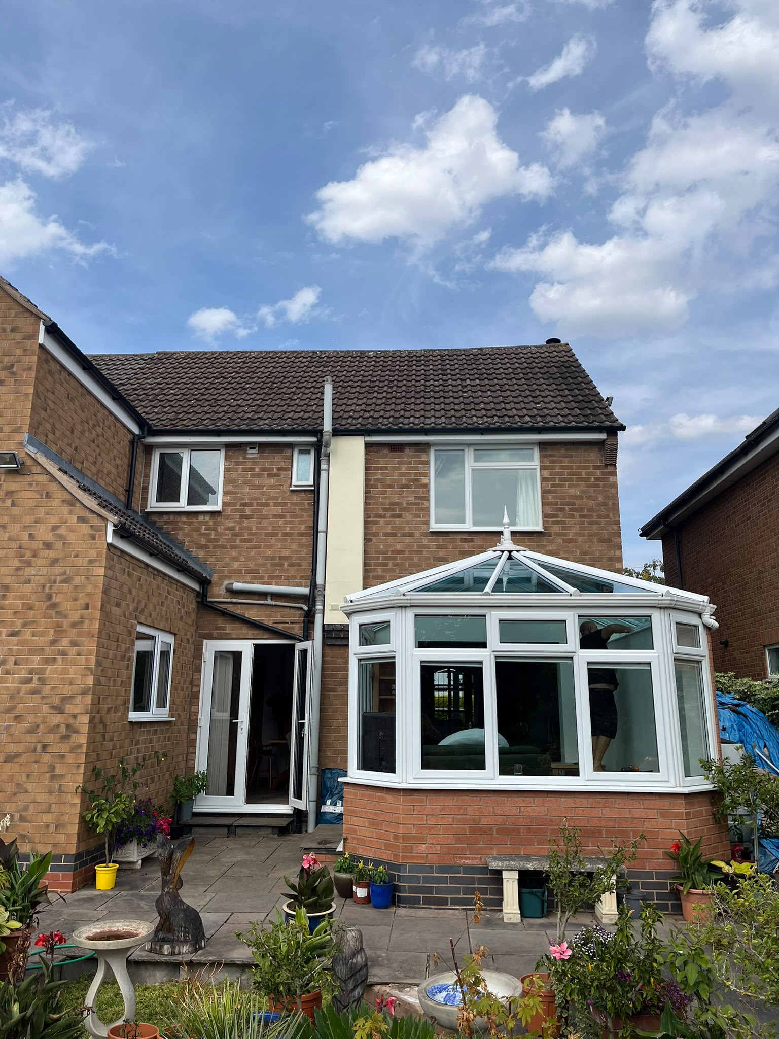 Conservatory glass roof being cleaned at the rear of a detached home